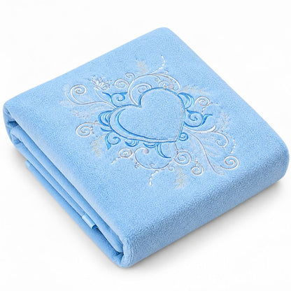 Couverture polaire bébé brodée coloris bleu ciel, pliée avec broderie cœur ornementale