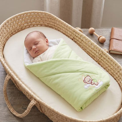 Bébé endormi dans un moïse en osier, couverture Good Night vert