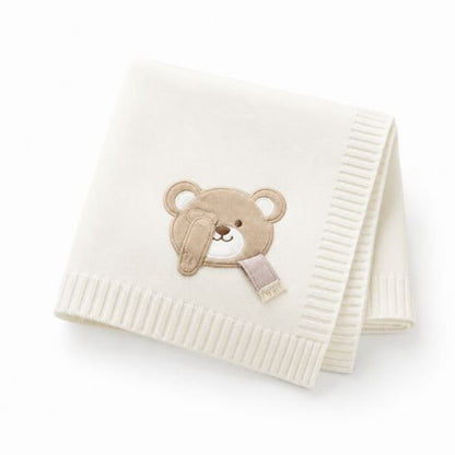 Couverture tricot pour bébé blanc écru avec ourson brodé, pliée