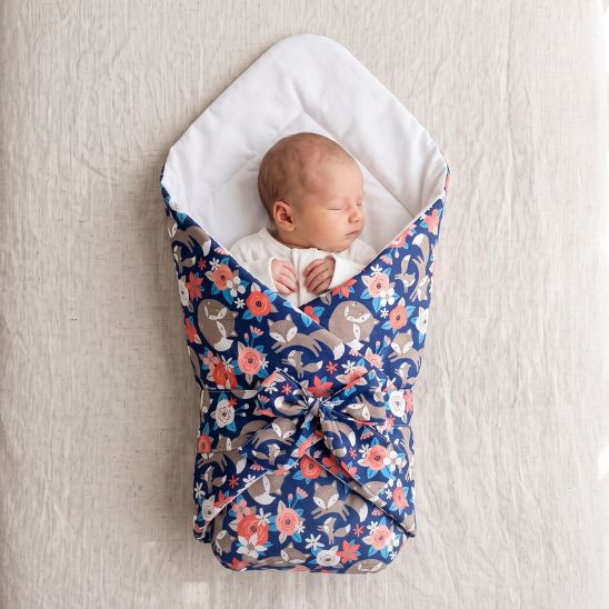Bébé endormi emmailloté dans une couverture motif Jardin Bleu Nuit