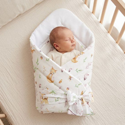 Bébé emmailloté dans son lit à barreaux, couverture motif Clairière Enchantée