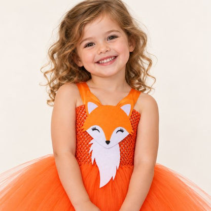 Gros plan sur le haut du déguisement renard : bustier en crochet orange, bretelles en satin et tête de renard en feutrine aux yeux souriants
