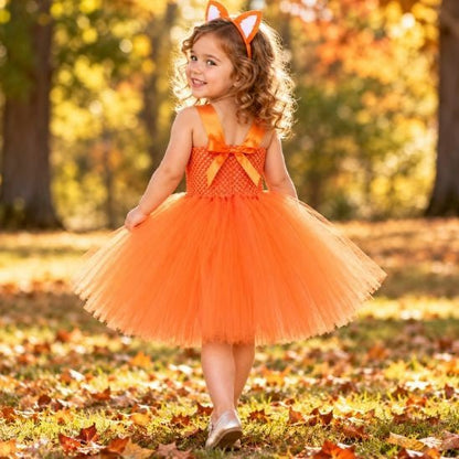 Dos du déguisement renard avec bretelles en satin croisées et nœud orange, porté par une petite fille qui se retourne en souriant