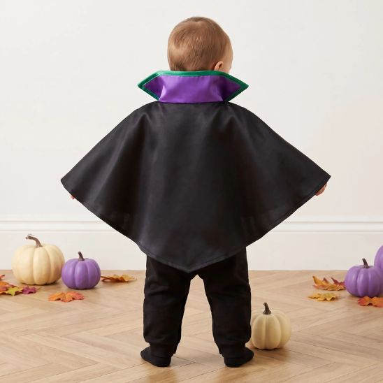 Bébé vu de dos avec déguisement Halloween et grande cape noire