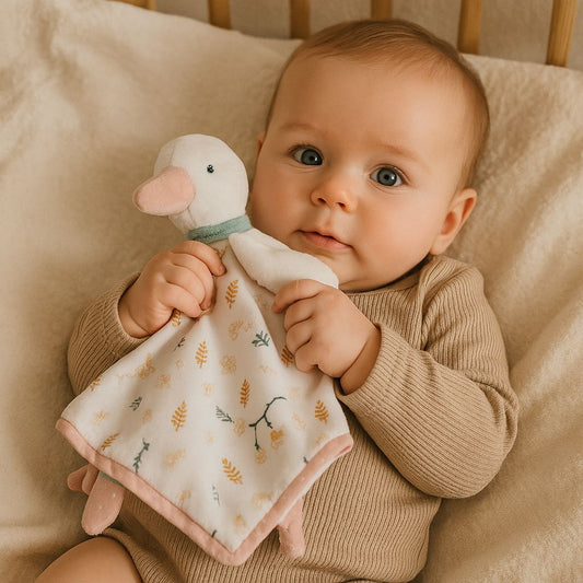 Bébé apaisé serrant son doudou oie dans les bras, ambiance douce et naturelle – Spot Bébé