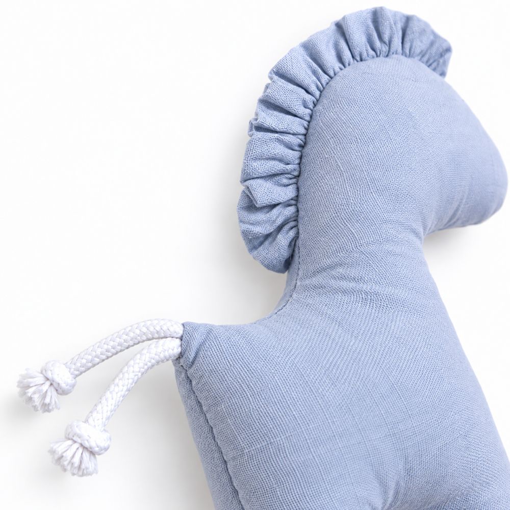 Gros plan sur la crinière et l'attache du doudou cheval bleu
