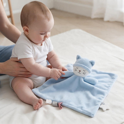 Bébé assis attrapant la patte de son doudou plat chat bleu