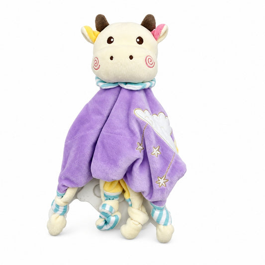 Doudou vache Pâquerette debout avec sa cape violette, ses étoiles brodées et ses coins noués à rayures