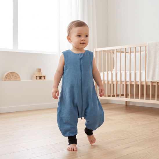 Bébé qui marche dans sa gigoteuse avec jambes bleu ardoise dans sa chambre