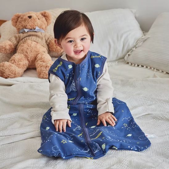Bébé portant une gigoteuse bébé garçon et fille TOG 1 motif galaxie bleu nuit.
