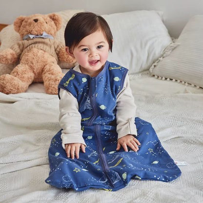 Bébé portant une gigoteuse bébé garçon et fille TOG 1 motif galaxie bleu nuit.