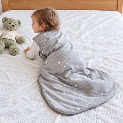 Tout-petit à quatre pattes dans sa gigoteuse grise étoilée