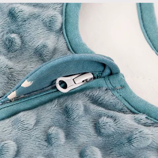 Gros plan sur la patte protège-fermeture au col, velours à pois en relief.