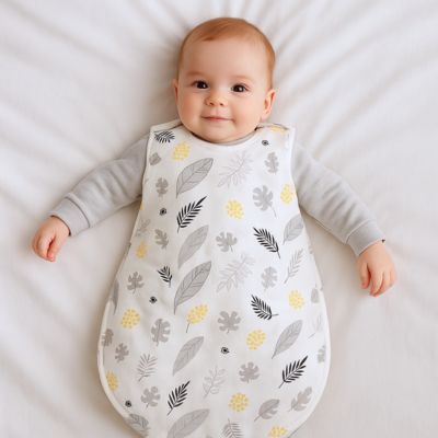 Bébé souriant portant gigoteuse coton imprimé gris et jaune