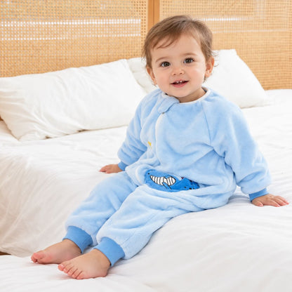 Enfant assis sur le lit en gigoteuse pyjama à jambes bleu ciel