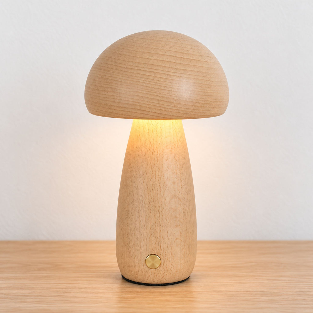Lampe veilleuse bébé champignon en hêtre allumée sur une table en bois clair