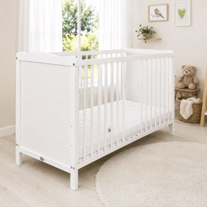 Lit bébé blanc dans une chambre naturelle lumineuse avec ours en peluche et tapis rond