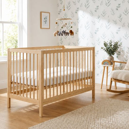 Lit bébé en bois naturel avec mobile musical animaux dans une chambre bébé lumineuse