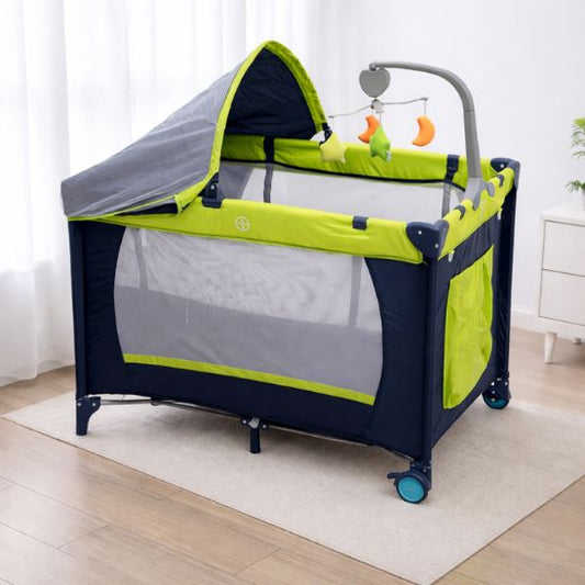 Lit parapluie bébé pliable avec mobile bébé installé dans une chambre