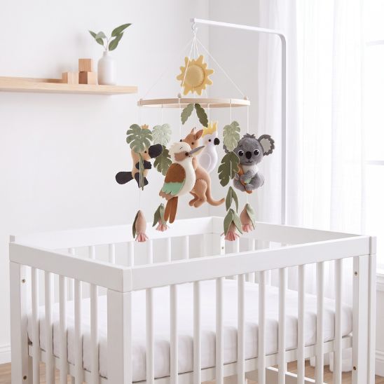 Mobile bébé Animaux Nature et Soleil installé sur un lit à barreaux avec bras blanc