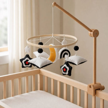 mobile bébé contrasté Pleine Lune sur un bras en bois au-dessus d'un lit à barreaux