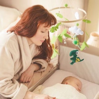 Maman regardant son bébé dormir paisiblement dans son berceau avec un mobile bébé dinosaure suspendu