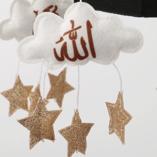 Mobile bébé musical kaaba islamique suspendu au-dessus d’un lit bébé dans une chambre décorée style scandinave