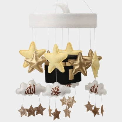 Mobile bébé musical kaaba islamique installé sur un berceau en bois clair dans une chambre bébé apaisante