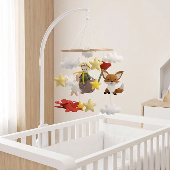 Mobile bébé Petit Prince installé avec son bras de fixation sur un lit à barreaux