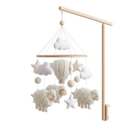 Mobile lit bébé moutons installé sur son bras en bois naturel