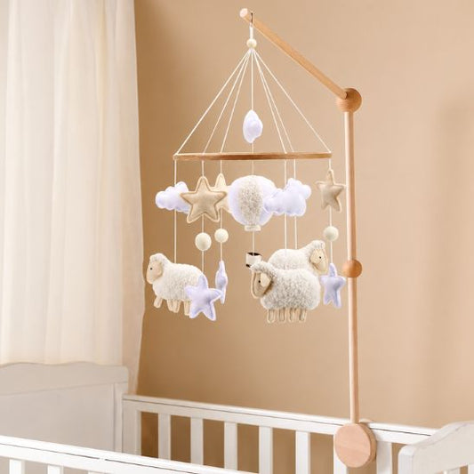 Mobile lit bébé moutons blancs bouclés installé sur bras en bois naturel au-dessus d'un lit à barreaux blanc étoiles beige et lavande nuages chambre bébé mixte