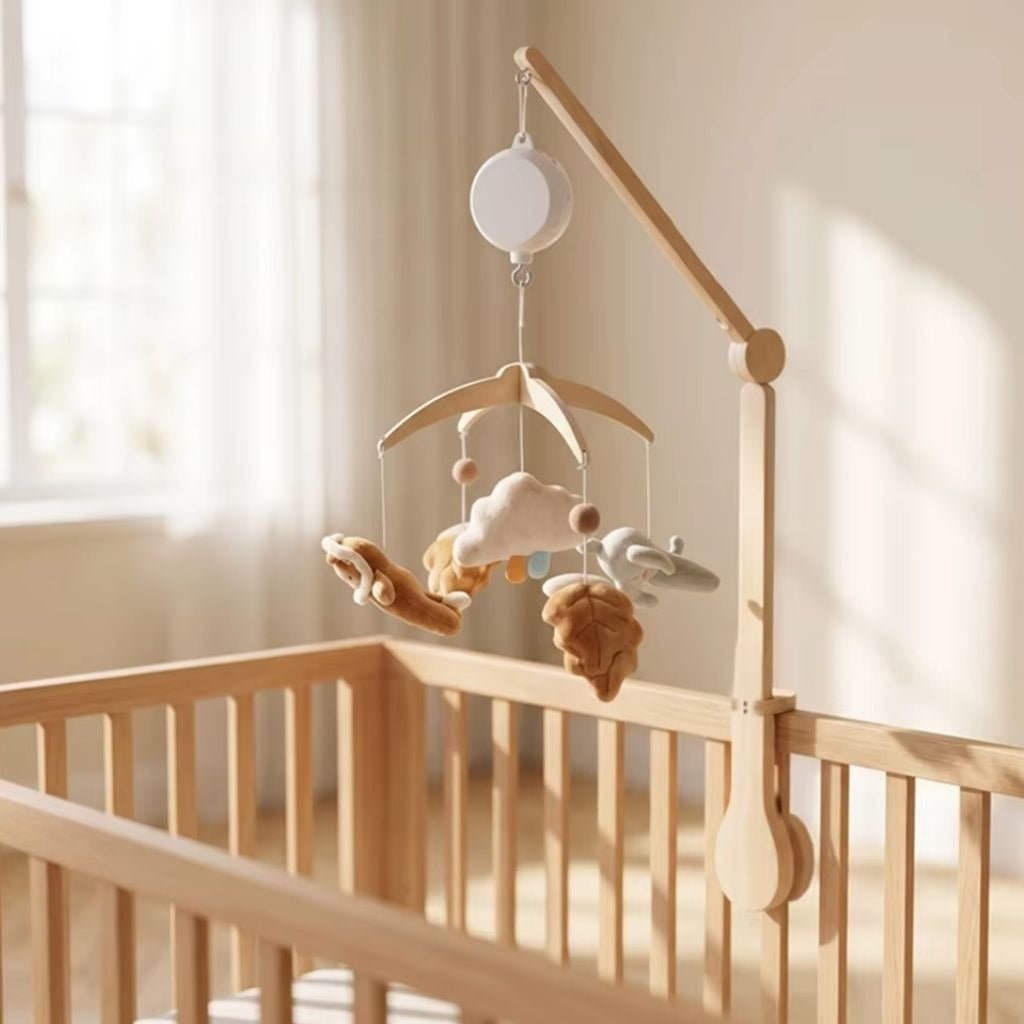 mobile musical bébé bohème fixé avec un bras en bois sur un lit à barreaux dans une chambre lumineuse