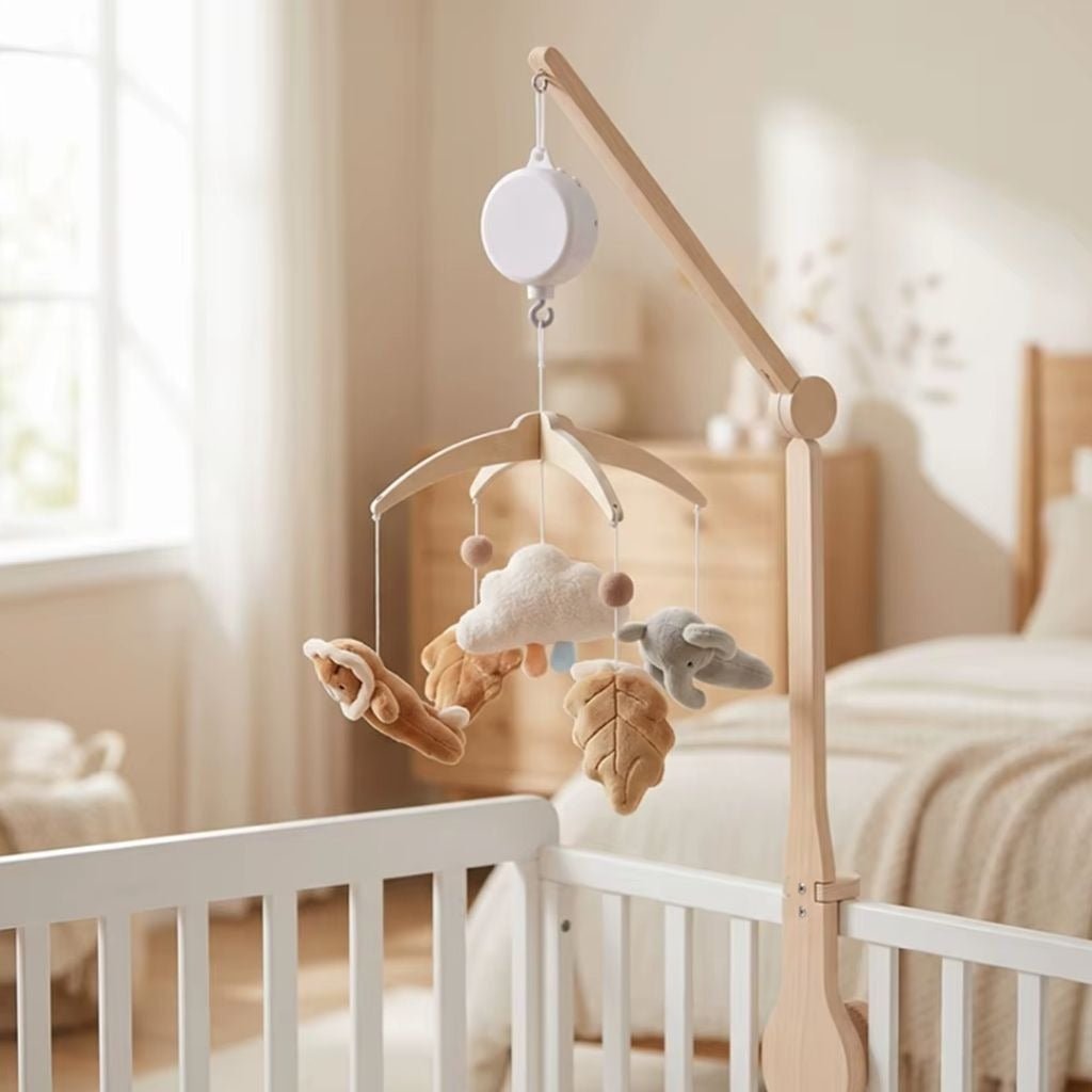 mobile musical bébé bohème avec bras en bois et boîte à musique Perle sur un lit blanc