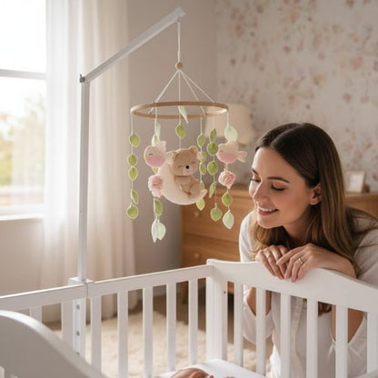 Mobile musical bébé fille Jardin de Lune — maman souriante penchée sur son bébé dans le berceau