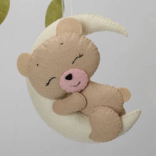 Détail mobile musical bébé fille Jardin de Lune — petit ours endormi sur sa lune en feutrine