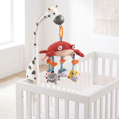 Mobile musical bébé lumineux installé sur un lit à barreaux blanc