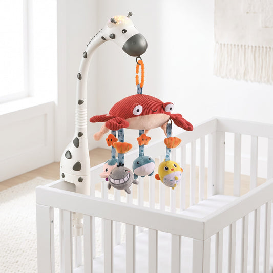 Mobile musical bébé lumineux installé sur un lit à barreaux blanc