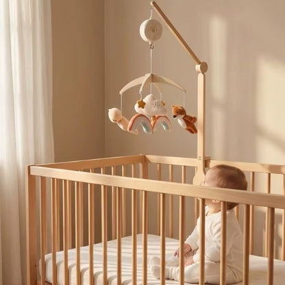 bébé assis dans son lit qui regarde le mobile musical renard en velours