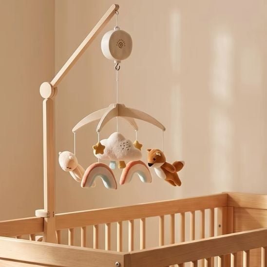 mobile musical bébé renard fixé sur un lit à barreaux avec bras en bois