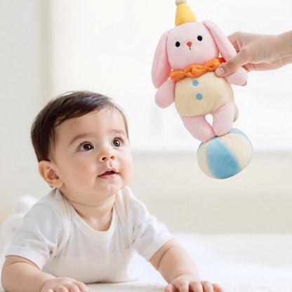 bébé qui regarde un lapin rose détachable du mobile musical bébé rotatif