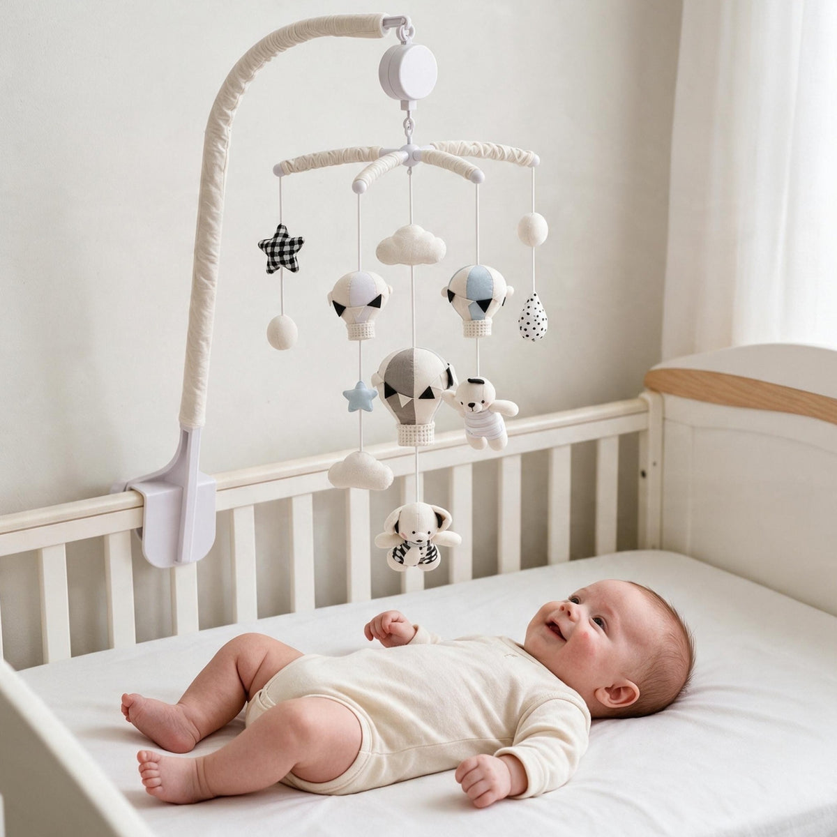 bébé allongé qui sourit en regardant le mobile musical bébé sans pile Escale au-dessus de son lit