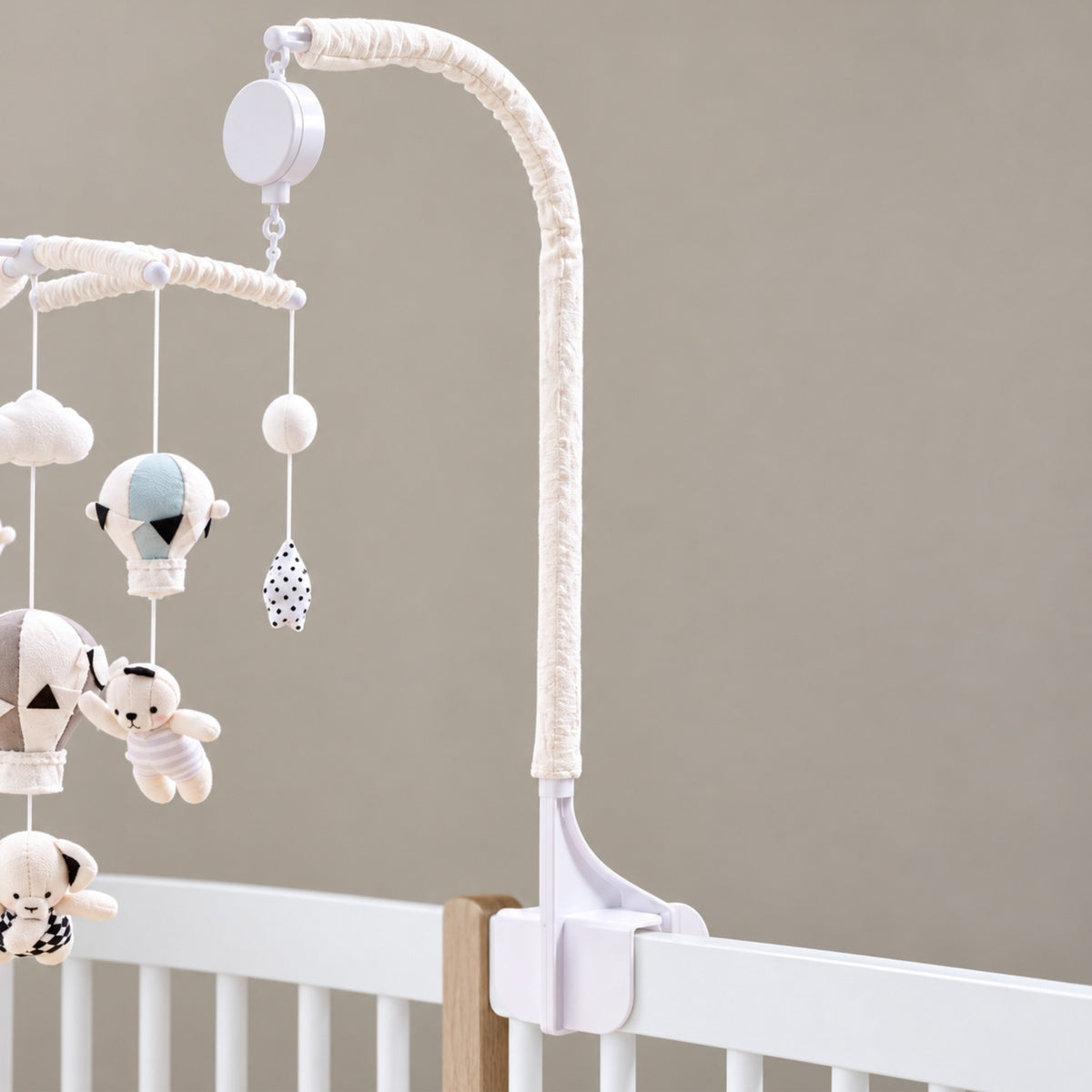 bras blanc avec pince à vis du mobile musical bébé sans pile Escale fixé sur un lit à barreaux