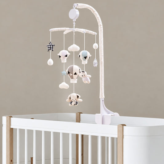 mobile musical bébé sans pile Escale avec montgolfières, ourson et nuages fixé sur un lit blanc et bois