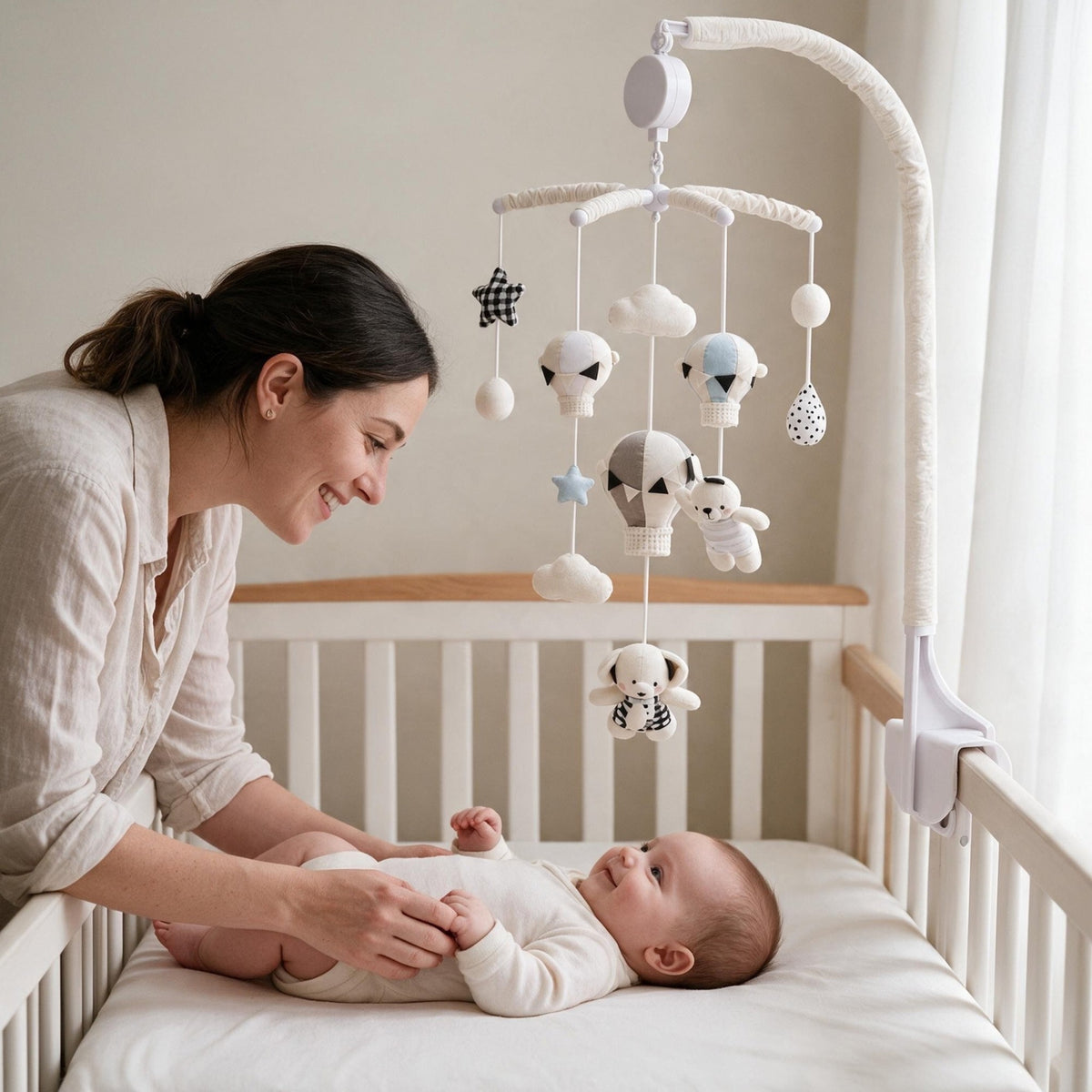 maman souriante penchée sur son bébé sous le mobile musical bébé sans pile Escale