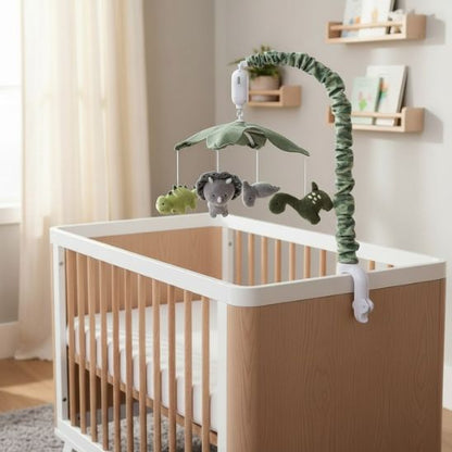 Mobile musical dinosaure jungle fixé sur lit bébé bois dans chambre garçon lumineuse