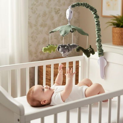 Bébé éveillé qui tend les bras vers le mobile musical dinosaure jungle dans lit bois