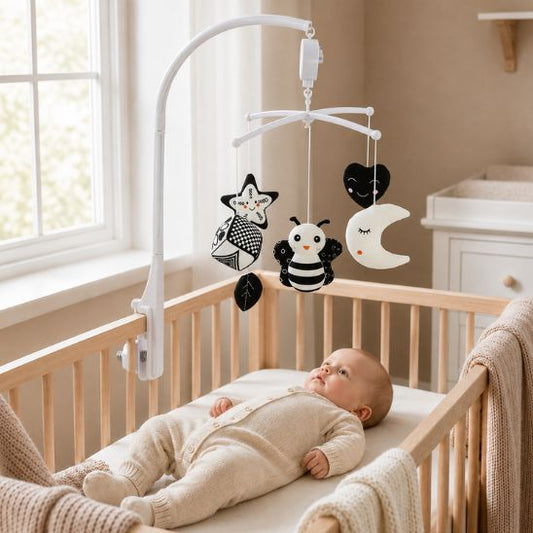Bébé allongé dans son lit sous le mobile musical noir et blanc