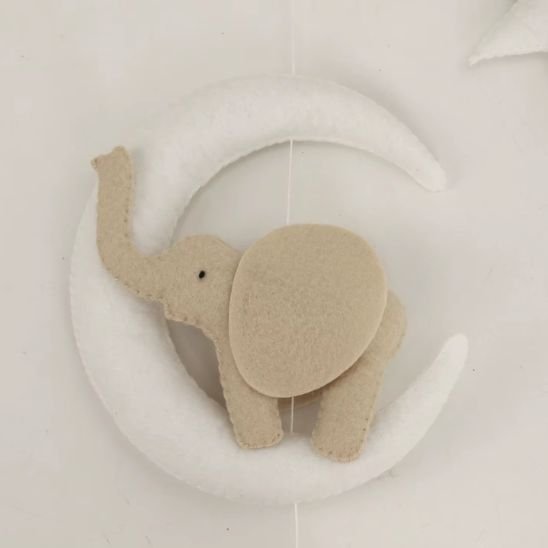 Mobile musical safari fait main — éléphant beige sur lune blanche en feutrine cousu à la main