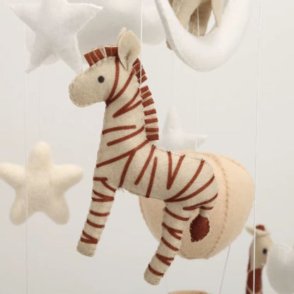 Mobile musical safari fait main — détail zèbre en feutrine cousu artisanalement tons beige terracotta