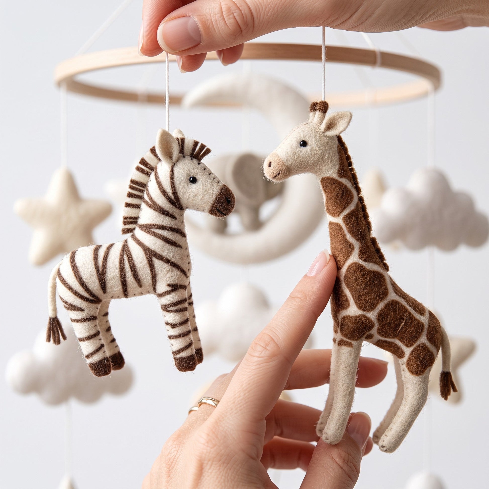 Mobile musical safari fait main avec zèbre et girafe en feutrine, détails artisanaux pour chambre de bébé